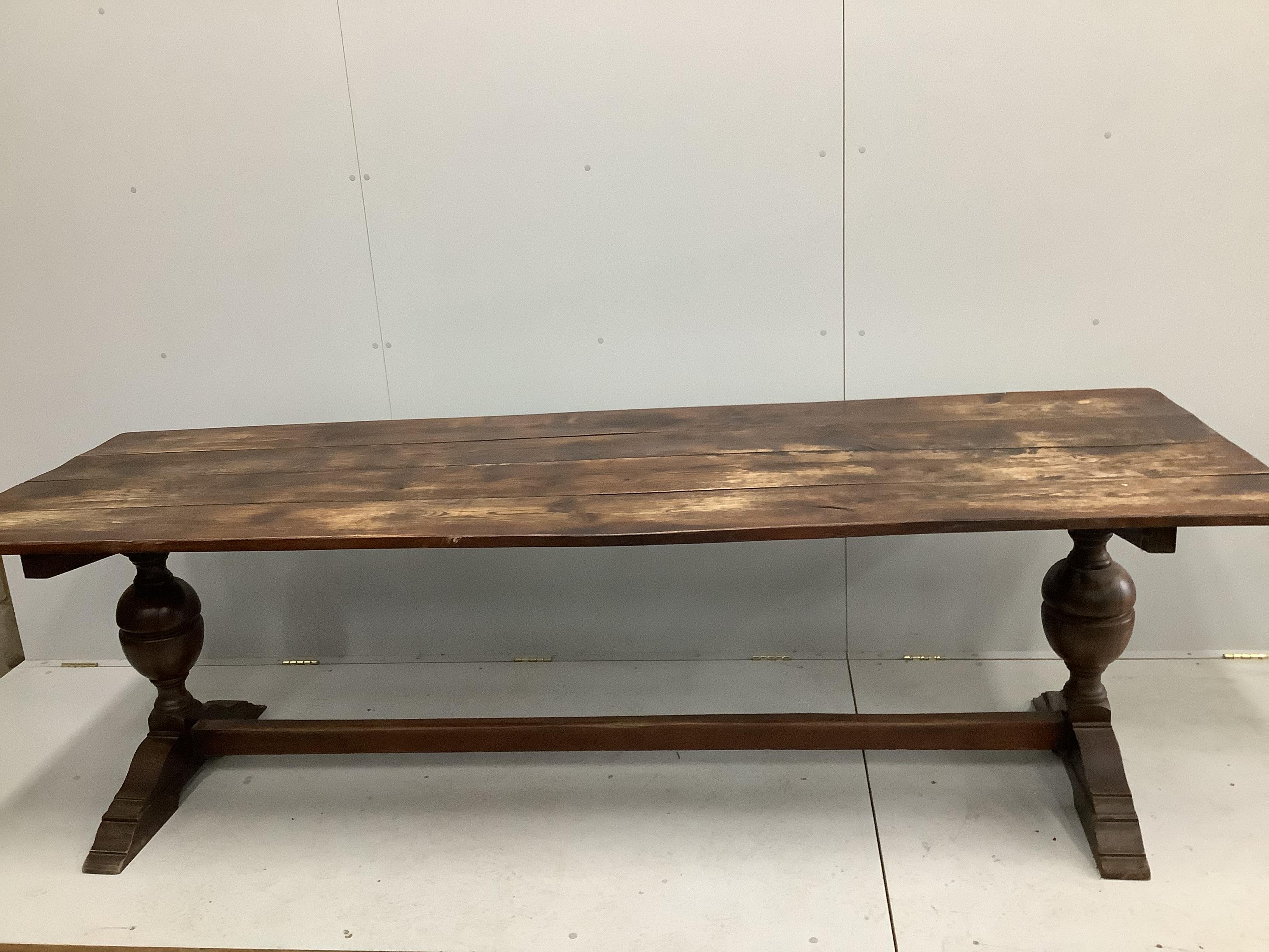 An 18th century style rectangular planked top oak refectory dining table, width 254cm, depth 84cm, height 75cm
